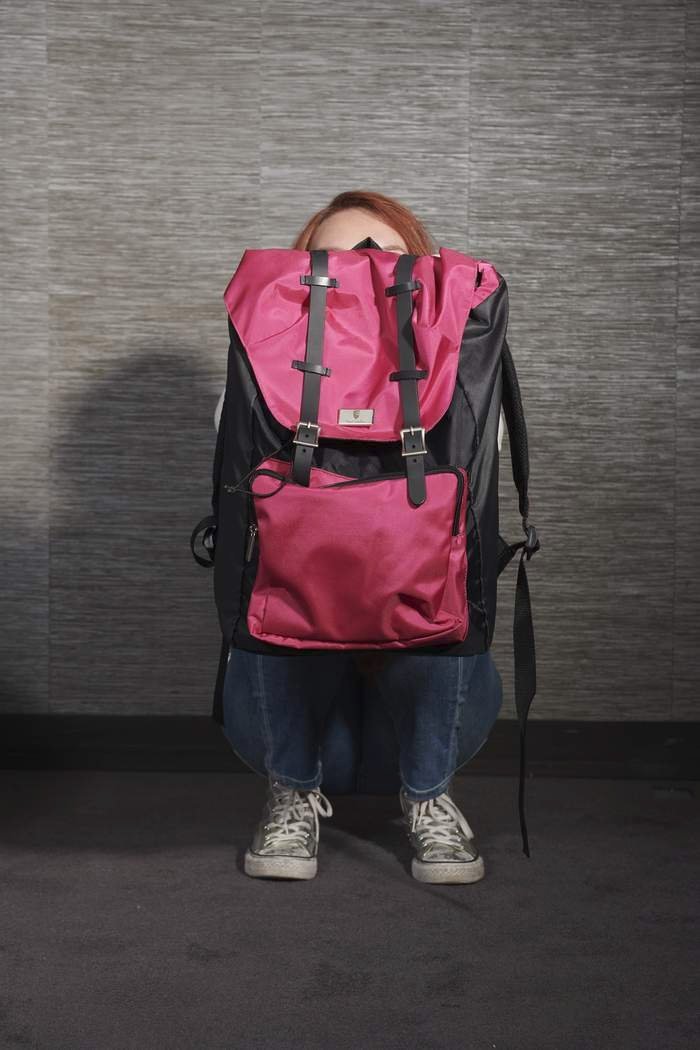 Dívka skrývající se za neprůstřelným batohem, (ilustrační foto).