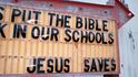 Bible do každé školy, Ježíš vás zachrání - píše se na ceduli. Takovou výzvu byste v modrých státech hledali marně.