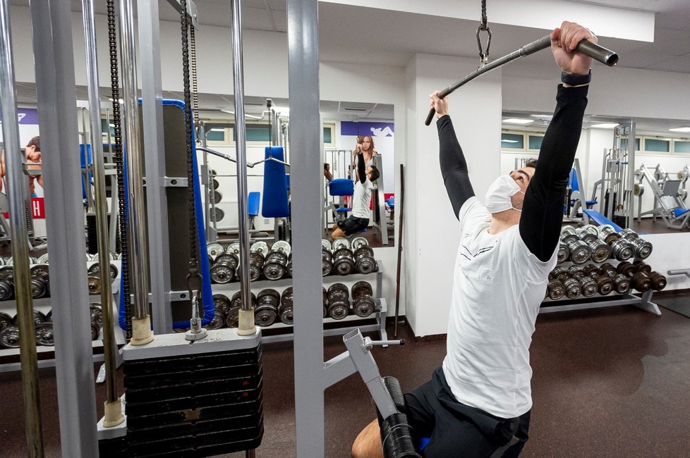 Muž s rouškou posiluje ve fitness centru areálu Klíše v Ústí nad Labem, který se otevřel po uvolnění vládních opatření proti šíření koronaviru (3. 12. 2020).