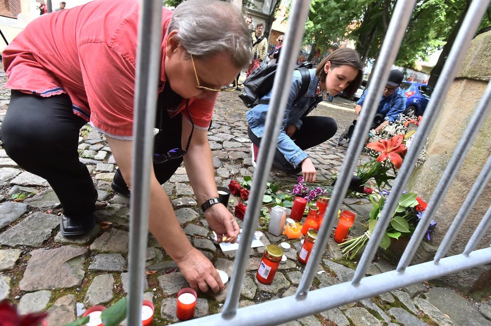 Lidé před francouzským velvyslanectvím v Praze zapalují svíčky.