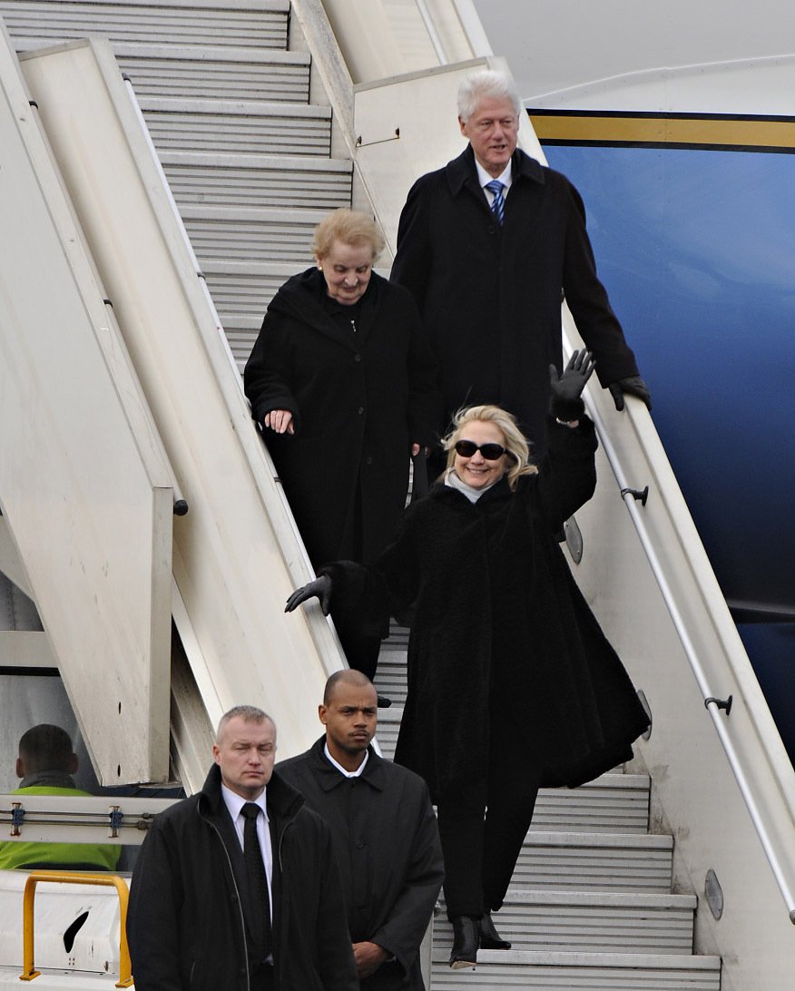 Hillary Clinton v doprovodu svého manžela a Madeleine Albright vystupují z letadla