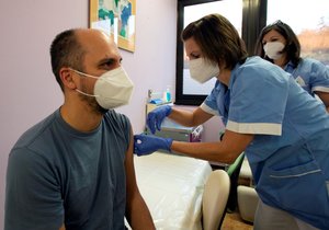 Pracovník motolské nemocnice v Praze dostává v den zahájení očkování proti nemoci covid-19 dávku vakcíny (27. 12. 2020)