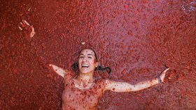Ulice španělského městečka Buňol nedaleko Valencie se dnes opět zbarvily dočervena, a to díky 130 tunám rajčat, která po sobě házeli lidé během tamní tradiční slavnosti zvané Tomatina.