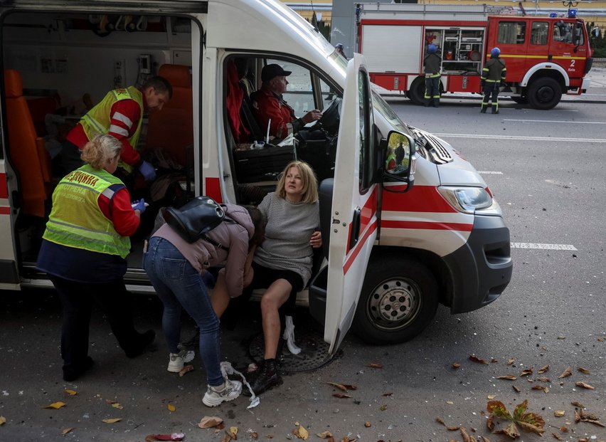 Záchranáři ošetřují zraněné po ostřelování Kyjeva (10. 10. 2022)