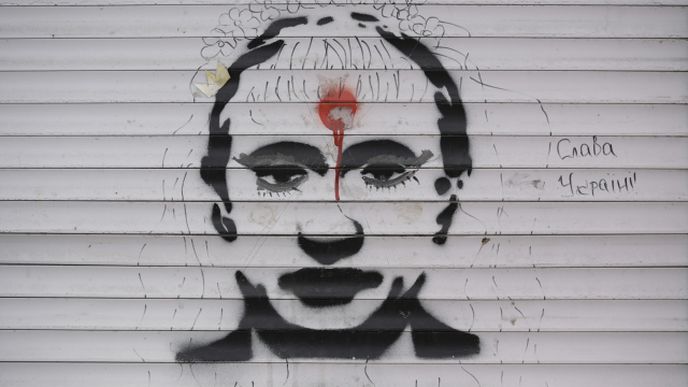 Graffiti zobrazující ruského prezidenta Vladimira Putina a slova „Sláva Ukrajině“ na roletách obchodu poškozeného bitvou ve Stojance na Ukrajině