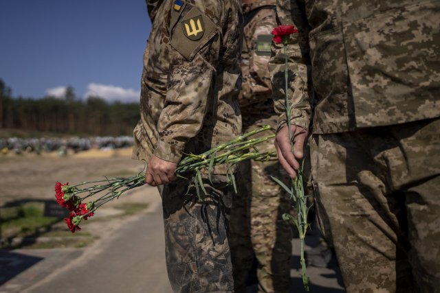 Ukrajinští vojáci v Irpini pokládají květiny na hroby svých spolubojovníků.