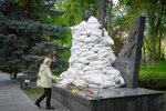 Válka na Ukrajině: Žena pokládá květinu na hrobku neznámého vojína, který padl za druhé světové války (9.5.2022)