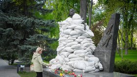 Válka na Ukrajině: Žena pokládá květinu na hrobku neznámého vojína, který padl za druhé světové války (9.5.2022)