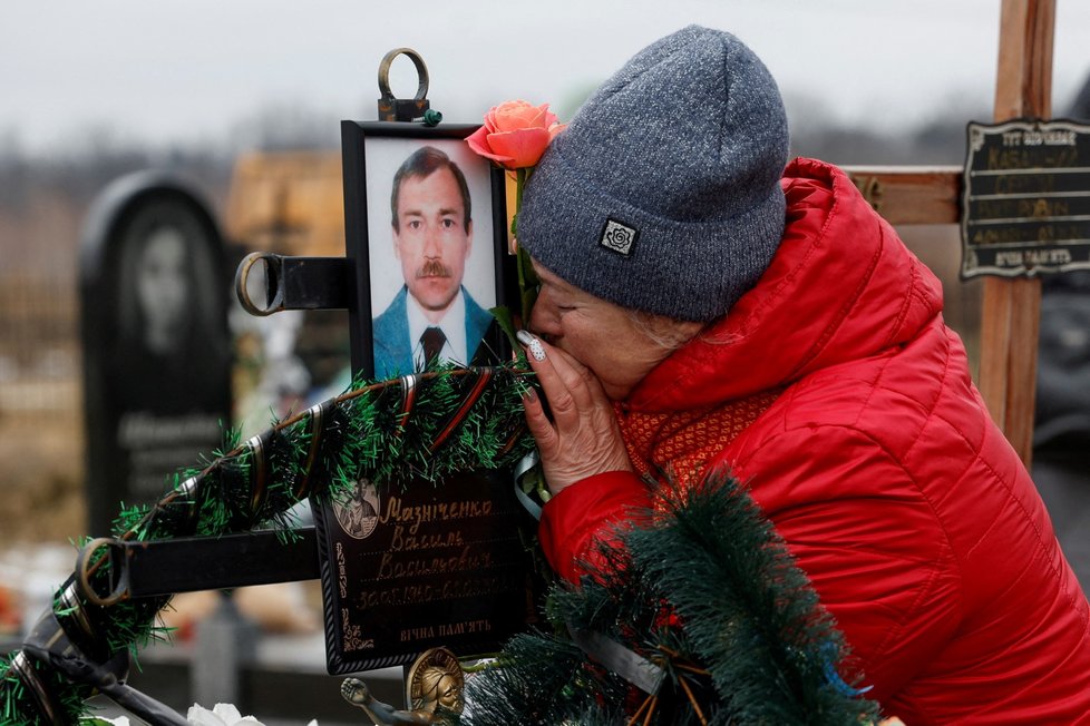 Lidé z Buči navštěvují hroby svých příbuzných v den prvního výročí ruského útoku na Ukrajinu