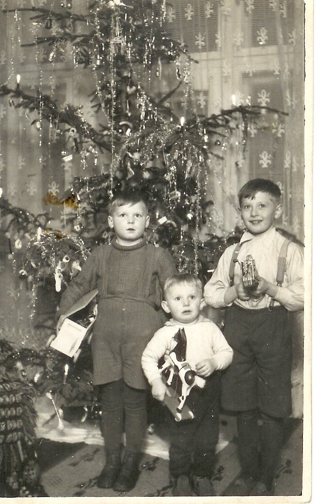 Fotka je z roku 1937, je na ní můj strejda, tehdy sedmiletý (první zleva) a jeho dva bratranci. Ukazuje, že v té době malí kluci nosili jen punčochy a krátké kalhoty na kšandy, a taky to, že bylo zvykem dát každému dítěti jen jednu hračku jako dárek, zbytek tvořily sladkosti či oblečení.