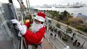 Vánoce si lidé připomínají po celém světě - i tam, kde jejich oslavy nepatří k místním tradicím. Japonský myč oken se na svou vánoční směnu v Tokiu netradičně převlékl za Santa Clause. (Foto ČTK)