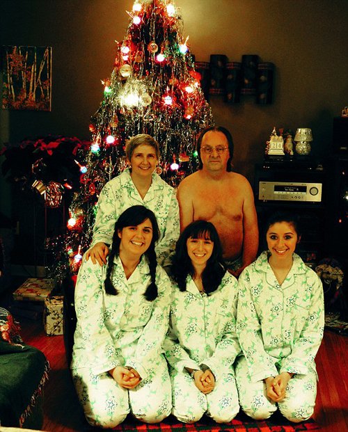 Šílené vánoční fotky: Rodinná pohoda u stromečku v pyžamech. Jen otec rodiny v Adamově rouše působí dost nepatřičně.