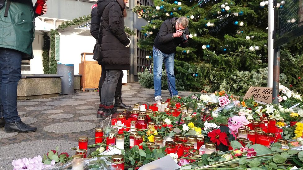 Pietní místa stále zůstávají, lidi přidávají svíčky i květiny.