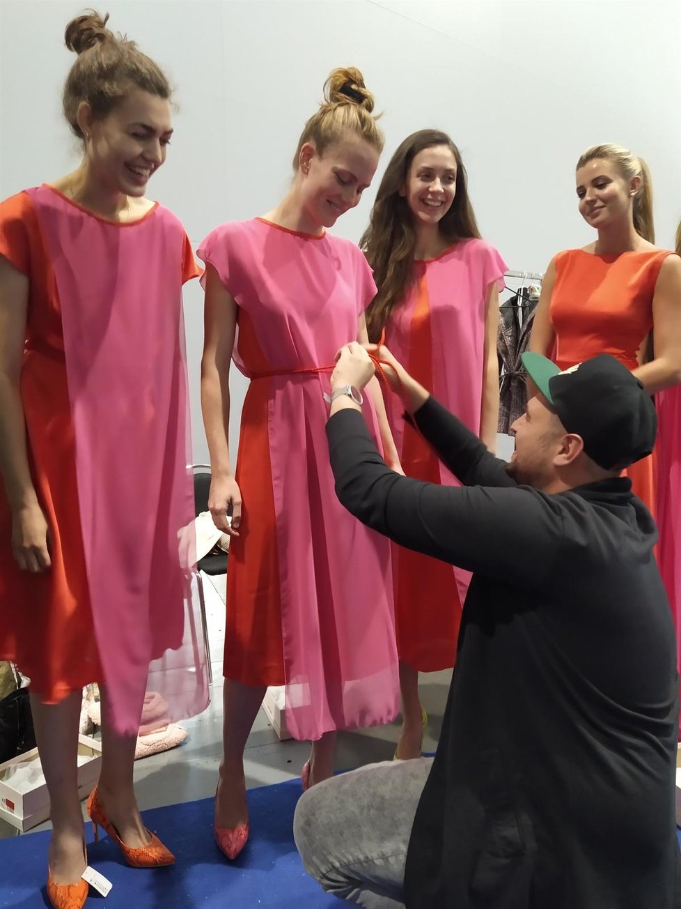 Návrhář Luděk Kellner upravuje na modelce šaty.