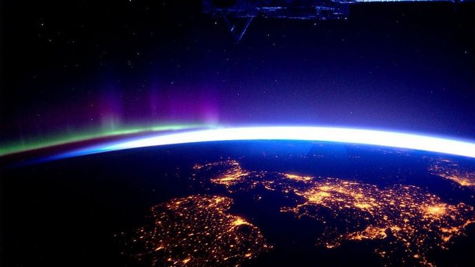 Velká Británie a Severní Irsko v noci (v dálce je vidět polární záři – auru borealis)