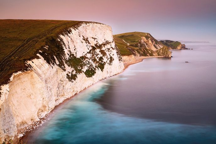 Křídové útesy, jako tenhle u Swyre Head, vznikly na dně moří rozpadem mikroorganismů a postupného stlačení jejich kalcitových schránek Křídové útesy, jako tenhle u Swyre Head, vznikly na dně moří rozpadem mikroorganismů a postupného stlačení jejich kalcitových schránek