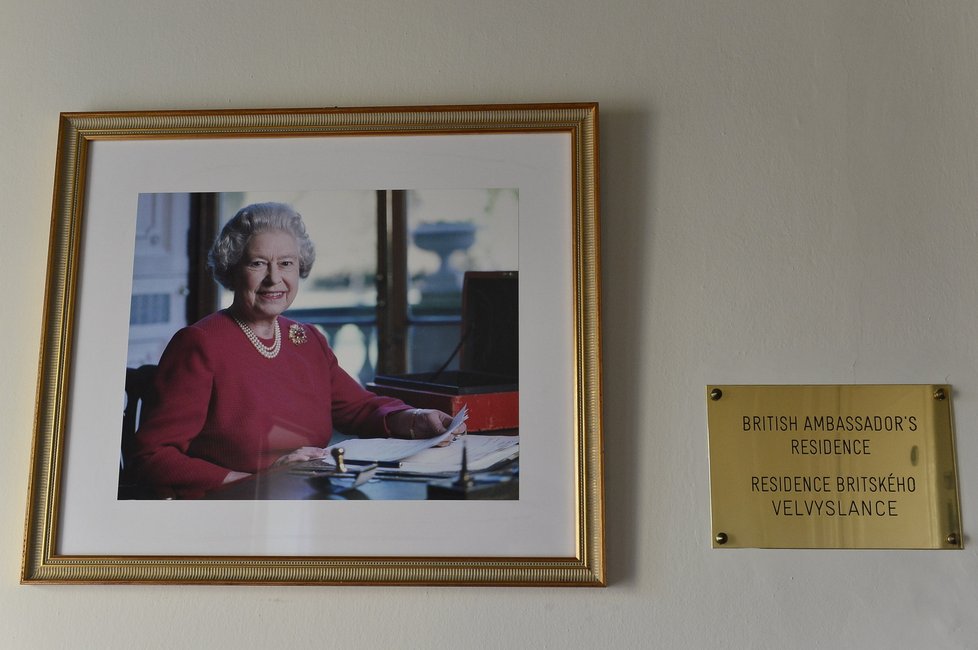 Při vstupu do rezidence se na návštěvníky z fotografie usmívá britská královna Alžběta II.