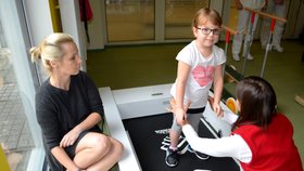 Verunka (7) udělala první krůčky teprve loni díky speciálním rehabilitacím v Klimkovicích. Rodina shání peníze, aby mohla dívka cvičit i letos. Maminka Pavla (v pozadí) doufá, že finance sežene.