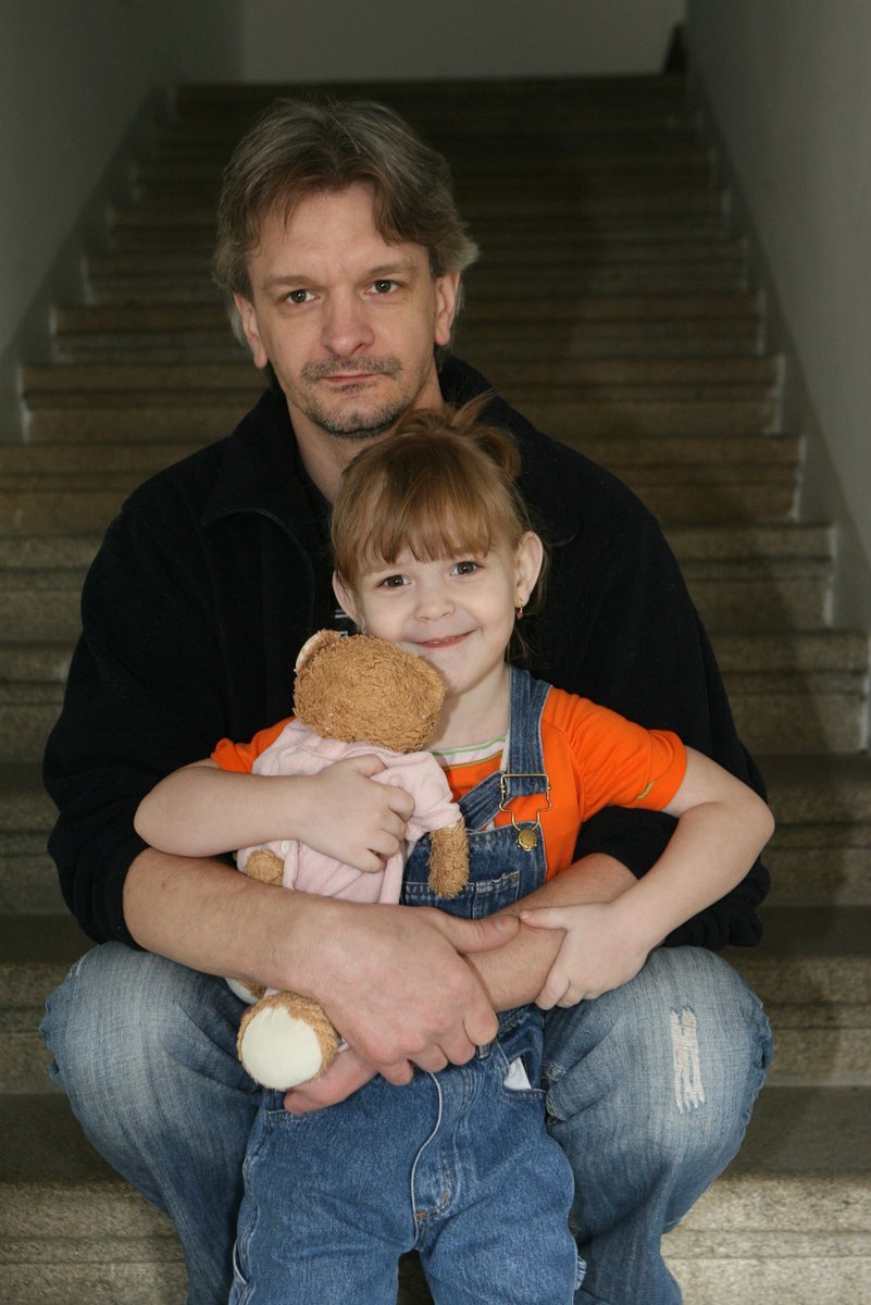 Holčičku drží v objetí tatínek.