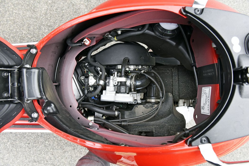 Podsedlový prostor o objemu 16,6 litru otevřete tlačítkem před koleny nebo dálkově klíčkem, pojme i integrálku. Celý kbelík můžete vyjmout, vyčistit a pohodlně se tak dostanete k motoru.