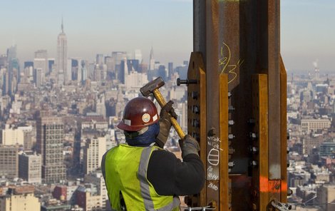 Historický okamžik. Dělník připevňuje ocelový »trám«, který udělal z Věže svobody nejvyšší budovu v New Yorku. Vyšší než majestátní Empire State Building (v pozadí).