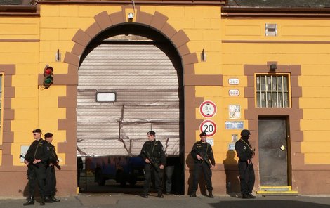 Zničenou bránu věznice hlídali policisté.