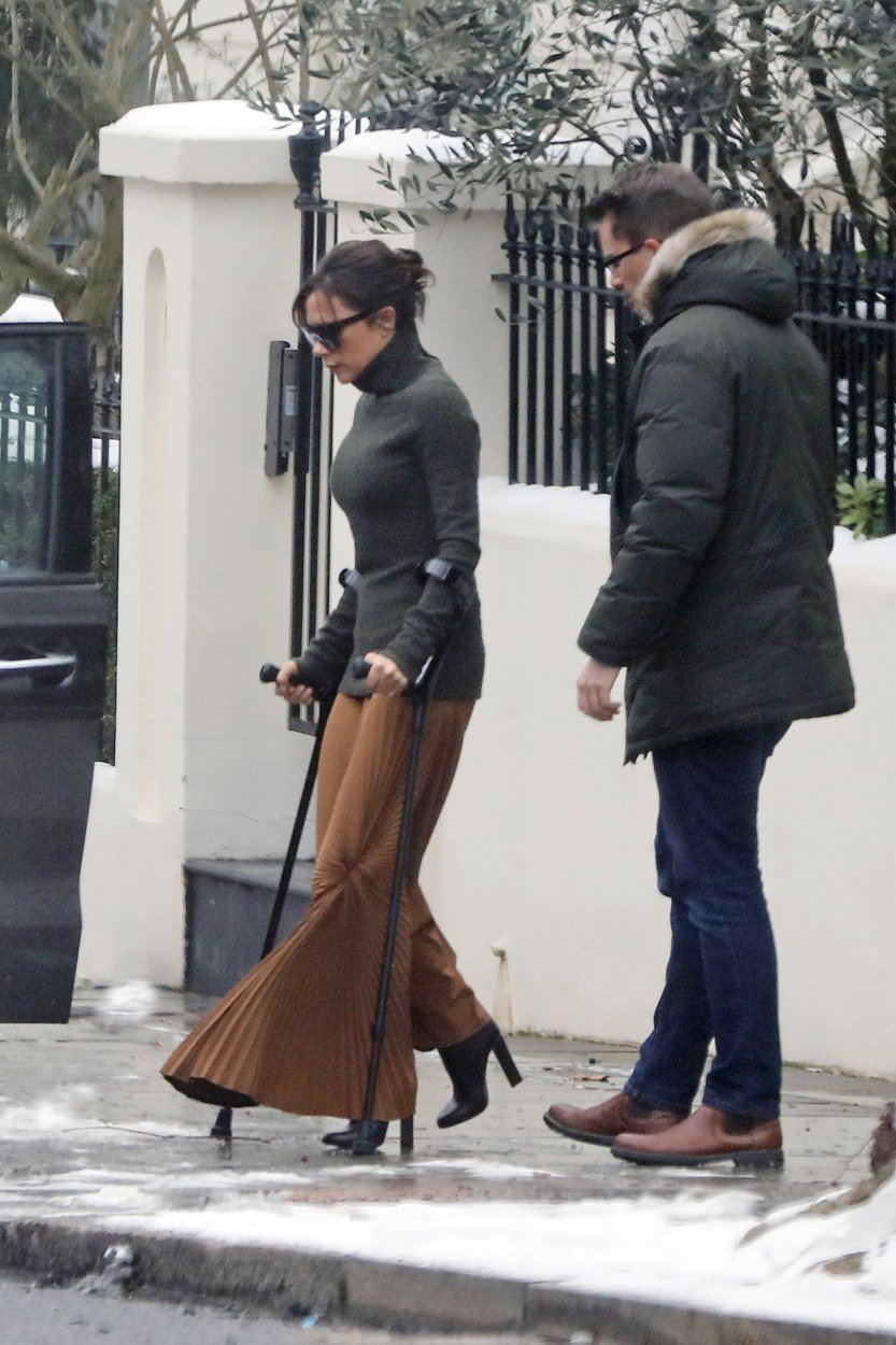 Victoria Beckham o berlích v botách na podpatku a bez kabátu.