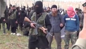 Vpředu má džihádista John alias Mohammed Emwazi proslov, vzadu za ním stojí muž s rudým vousem, Abu Omar al - Shiskani.
