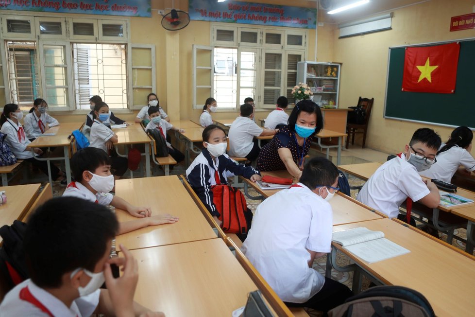 Školáci ve Vietnamu se po třech měsících vrátili do tříd. Čekalo je měření teploty i výuka v rouškách. (4. 5. 2020)