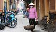 Ženy v tradičních kloboucích se snaží prodat svou zeleninu, mladí dohánějí západní módu.