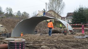 Stavbyvedoucí (otočen zády) se ze staveniětě mostu ve Vilénově nehny nyní na krok.