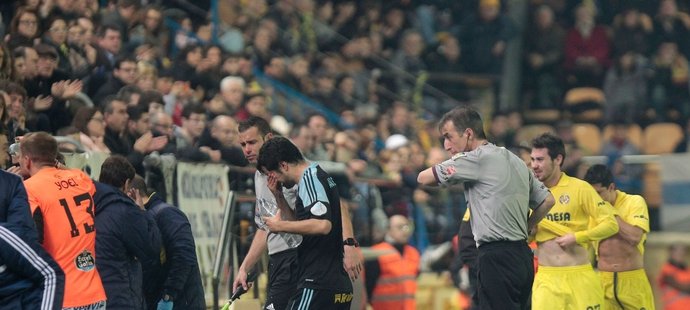 Fotbalisté i rozhodčí utíkají před slzným plynem do útrob stadionu.