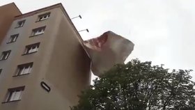 Silný vítr v Praze: Hasiči museli z budovy sundat vlající billboard, řešili i polámané stromy