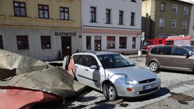 Plechová střecha poškodila zaparkovaná auta