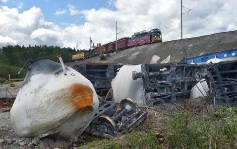Dělníci začali včera opravovat trakční vedení, které poškodila havárie nákladního vlaku. Na místě stále zůstává několik zničených vagónů.