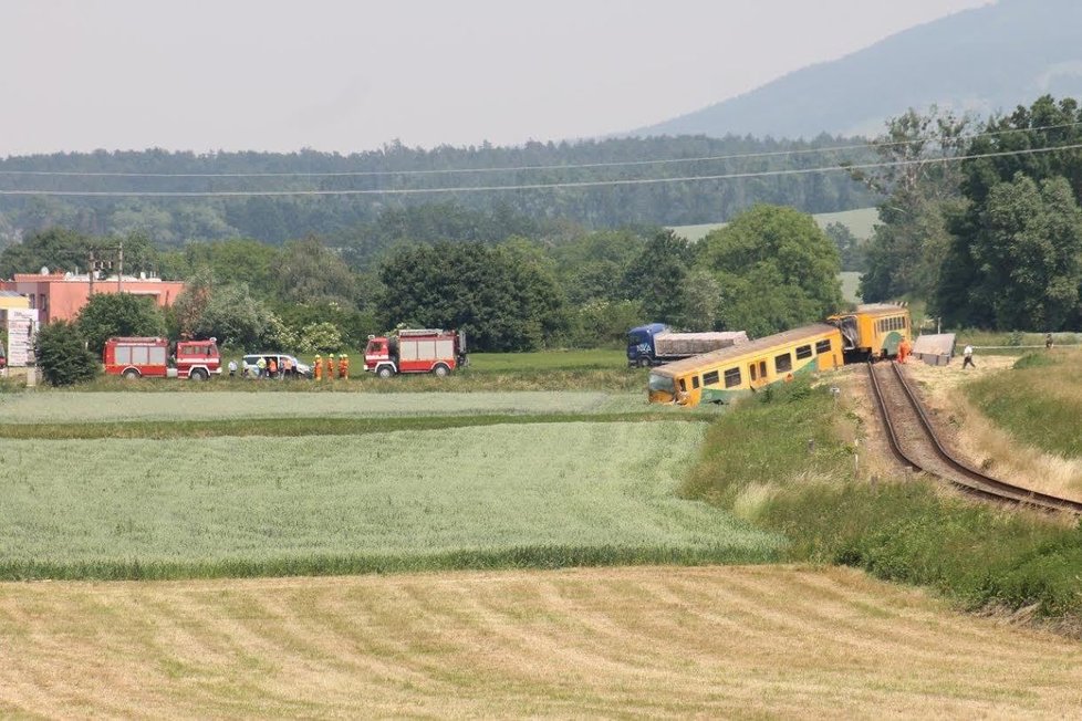 Řidič náklaďáku vjel na nechráněný přejezd ve chvíli, kdy tudy projížděl vlak. Při nehodě se zranily tři osoby.