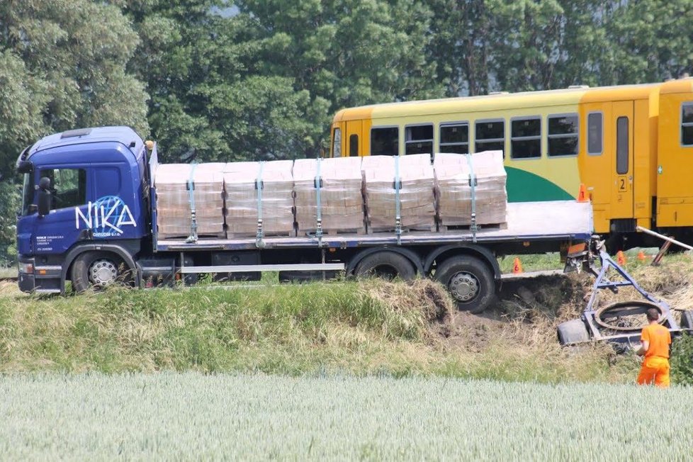 Řidič náklaďáku vjel na nechráněný přejezd ve chvíli, kdy tudy projížděl vlak. Při nehodě se zranily tři osoby.