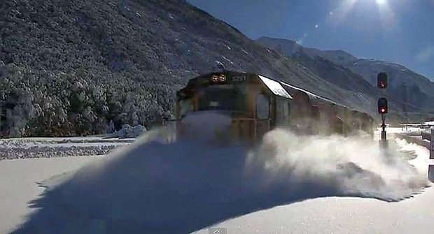 Vzpomínka na zimu: Vlak se brodí tunami sněhu