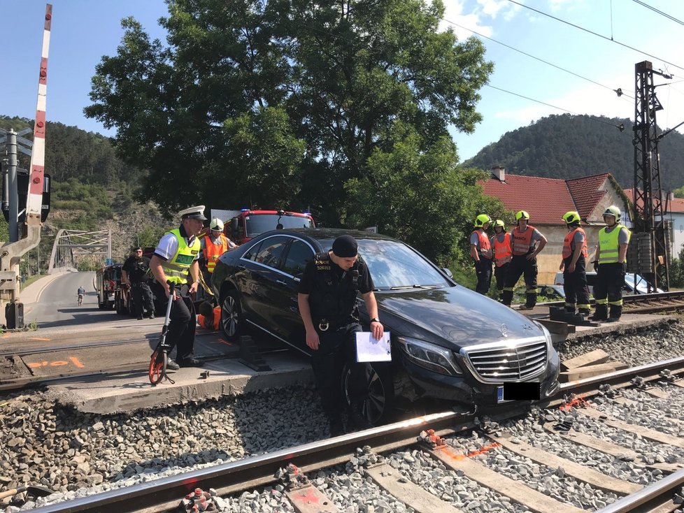 Řidič mercedesu uvízl na kolejích.