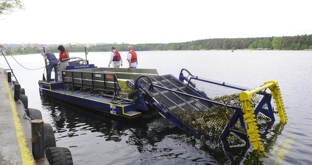 Vodní kombajn čistí zarostlé jezero v Hlučíně.