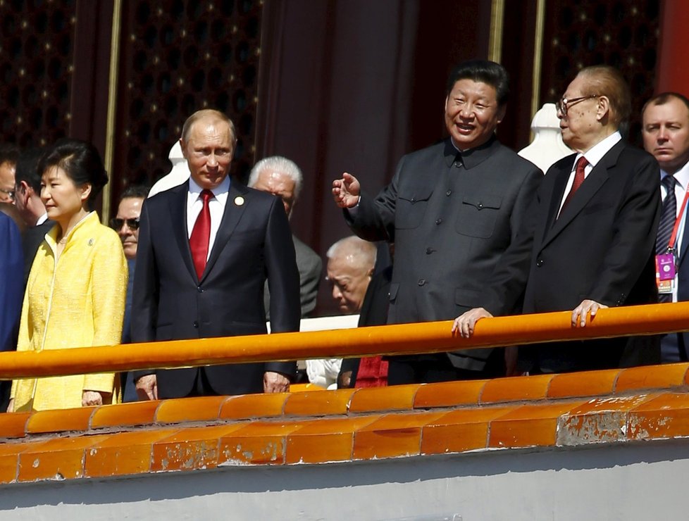 Čínský prezident Si Ťin-pching se svým předchůdcem Ťiang Ce-minem (vpravo) na vojendské přehlídce. Vlevo stojí ruský prezident Vladimir Putin.