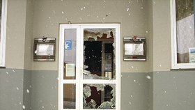 Detalní záběr na rozbité dveře a okna zavřeného hotelu Bobík