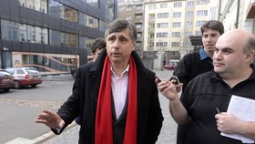 Jan Fischer s rudou šálou na krku promlouvá k novinářům