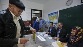 Muž v tureckém Istanbulu vhazuje volební lístek do urny.