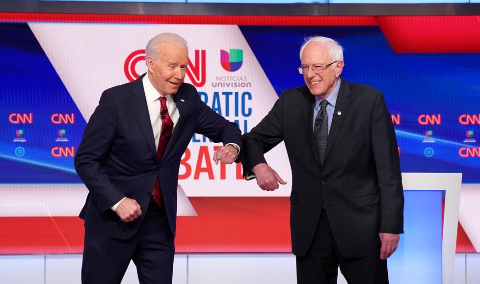 (Zleva) Viceprezident Joe Biden a senátor Bernie Sanders na debatě demokratických kandidátů na prezidenta si podali ruce loktem. (16.3.2020)