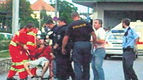 Vrah v péči záchranářů krátce poté, co jej postřelili zasahující policisté. (2008)