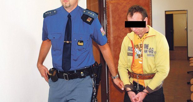 Vězeňská stráž přivádí Ukrajince Vasyla G. před vynesením rozsudku do soudní síně