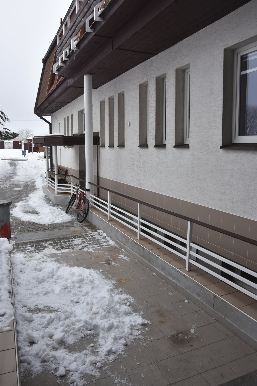 Žena ležela na chodníku (vpravo) v úrovni popelnice.