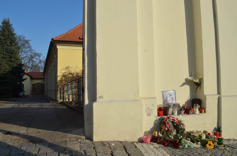 Před dvorkem, kde se střílelo vznikl na chodníku pomníček zavražděné s květinami a svíčkami i její fotkou