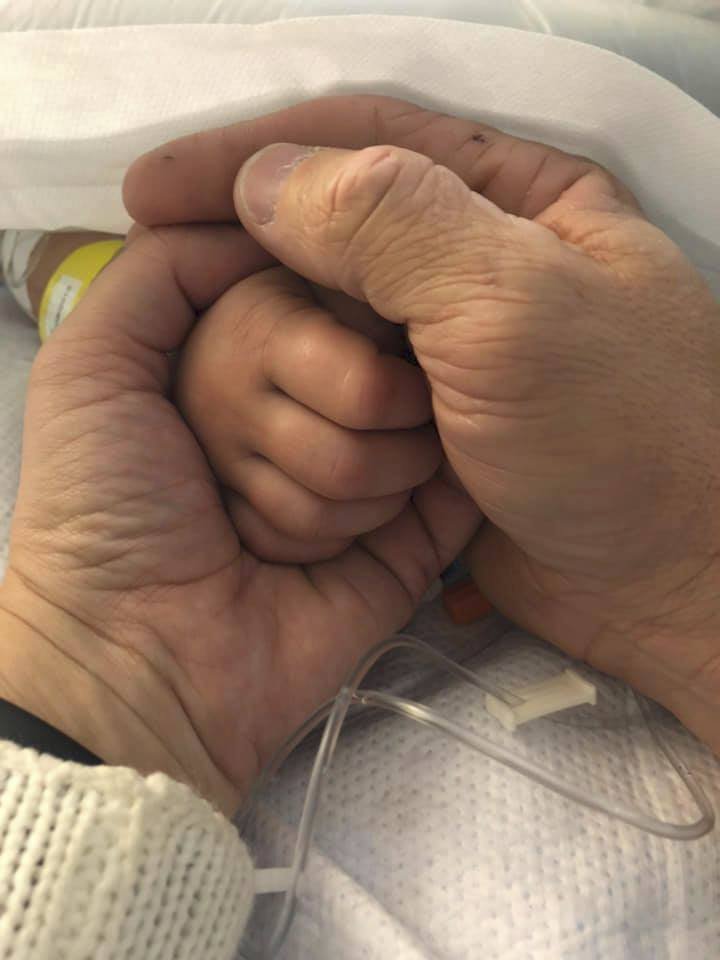 Otec bezmocně držel ručičku své holčičky. Fotografii sdílel na internetu.